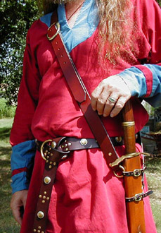 Our Versatile Baldric in Chestnut Leather shown from the side with sword hanging vertically.