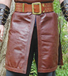 Riding split features folded leather trim with a double row of stitchwork. Bottom hem is stitched in matching fashion